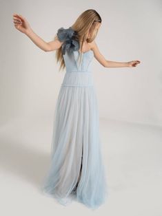 a woman in a blue dress with her arms outstretched