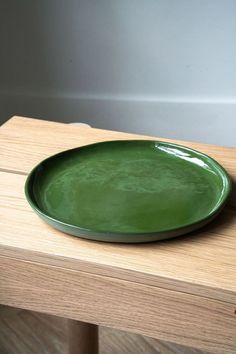 a green plate sitting on top of a wooden table