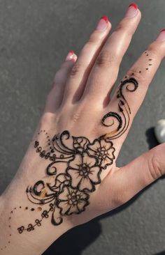 a woman's hand with henna tattoos on it