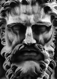 a black and white photo of a statue with a beard on it's face