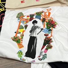 an image of a woman surrounded by flowers and plants on a white shirt with black pants