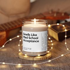 a candle sitting on top of a table next to a string of lights and a guitar