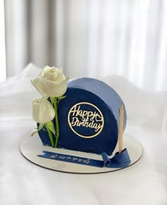 a blue birthday cake with white flowers on it