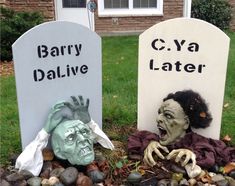 two tombstones decorated with creepy heads and fake hands