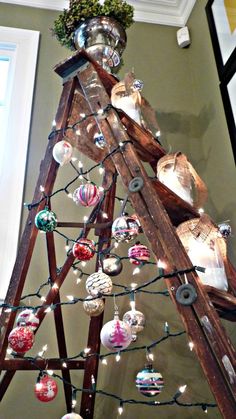 a christmas tree made out of old ladders with ornaments on it and lights hanging from the top