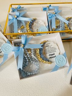 three boxes filled with blue and gold decorated cookies