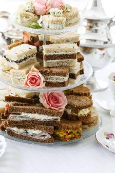 three tiered trays with sandwiches and flowers on them