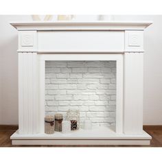 a white fireplace with two candles on it