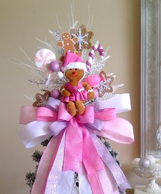 a pink and white christmas tree with a teddy bear