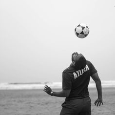 a man is playing with a soccer ball on the beach