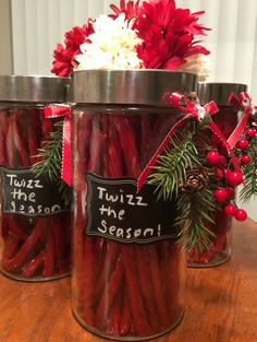 three jars filled with red hot dogs sitting on top of a wooden table