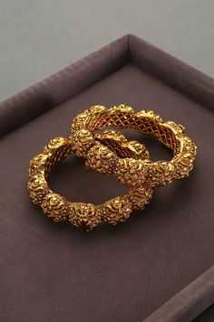 Gold Plated South Indian Temple Work embossed Bangles- set of 2. Beauty of South Indian temples now in your Jewelry wardrobe. Emboss work studded with classic stones and plated with 24kt gheru gold. South Gold never looked more authentic. Authentic designs for south indian brides or to match with your kanjeevaram silk sarees and banarasi silk dupattas. Attention to detail is our utmost goal. The Look Is Stunning And Preciously Suitable For All Kinds Of Dressy Occasions MEASUREMENT Bangle Size -2 Dubai Gold Bangles, Temple Work, Tanishq Jewellery, Unique Bangle