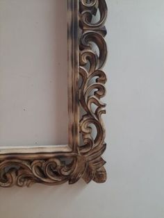 an ornate wooden frame hanging on the wall