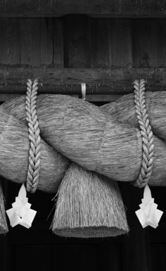 black and white photograph of rope hanging from the side of a building with paper stars attached to it