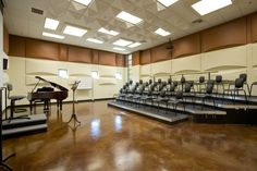 an empty concert hall with chairs and a piano