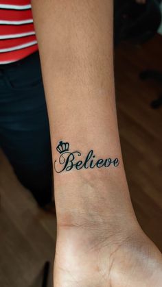 a person with a tattoo on their wrist that says believo in cursive writing