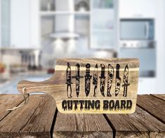 a cutting board with knives on it sitting on a wooden table in front of a kitchen