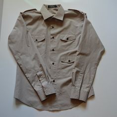 Men's Long-Sleeved, Button Up Dress Shirt. Has Three Pockets And Buttons On Shoulders. Never Worn. Beige Shirt With Buttoned Pockets, Beige Collared Shirt With Buttoned Pockets, Khaki Collared Shirt With Buttoned Pockets, Khaki Button-up Shirt With Button Closure, Fitted Khaki Button-up Shirt, Khaki Button-up Shirt With Button Cuffs, Khaki Button-up Shirt With Buttoned Pockets, Classic Fitted Shirt With Buttoned Pockets, Fitted Khaki Collared Shirt