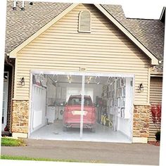 a red car is parked in the garage with its doors open and tools hanging on the wall