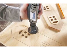 a person is using a drill to cut out holes in wood with a router