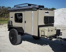 an off - road vehicle is parked in the sand with its cargo compartment on it's back