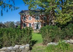 a large brick house surrounded by trees and bushes