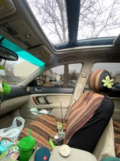 the interior of a car with stuffed animals and other items on the floor in it