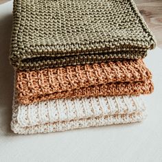 three knitted blankets sitting on top of each other