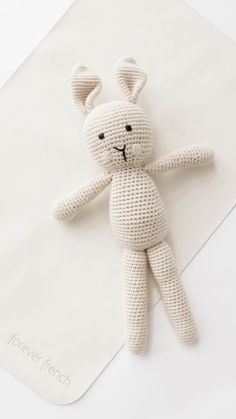 a crocheted stuffed animal laying on top of a white sheet