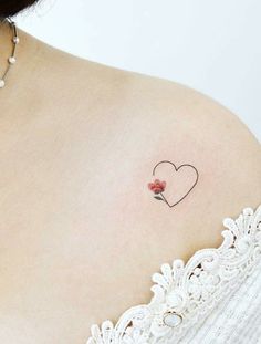 a woman with a small heart tattoo on her shoulder