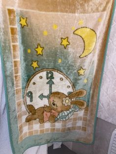 there is a towel with a teddy bear on it and a clock in the background