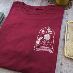 a red t - shirt sitting on top of a table next to a cookie tin