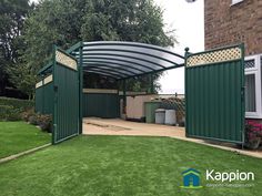 a large green metal structure in the middle of a yard