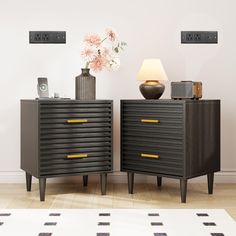 two nightstands with flowers on top of them in front of a white and black wall