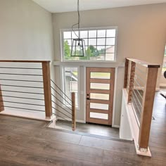 an empty living room with stairs leading up to the second floor and another open door