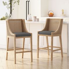 two wicker bar stools sitting in front of a counter