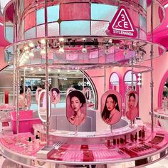 the inside of a beauty store with pink walls and round display shelves filled with cosmetics