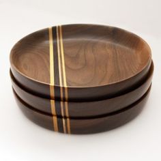 three wooden bowls with yellow stripes on them