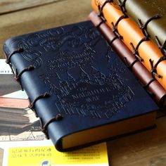 three different colored books sitting next to each other on top of a wooden table,