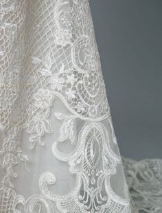 the back of a white dress with lace on it