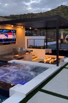 an outdoor living area with fire pit and television