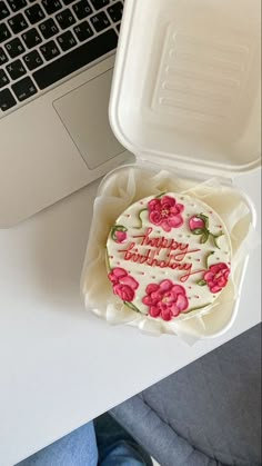 a birthday cake sitting in front of a laptop