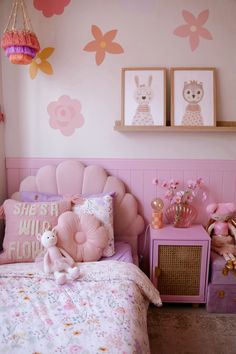 a bedroom with pink furniture and decor on the walls