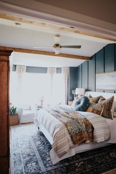 a bedroom with a bed, rug and ceiling fan in the middle of the room