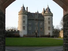 an archway leading to a large castle like building with turrets on it's sides