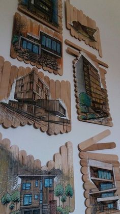 wooden cutouts with pictures of houses and windows on the side of a white wall