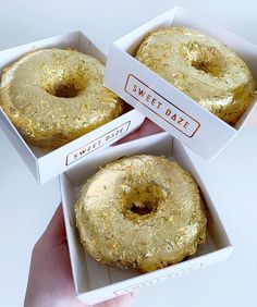 three boxes filled with donuts sitting on top of a table