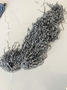 a pile of silver wire sitting on top of a white counter