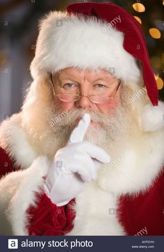 a man dressed as santa claus holding his finger up to his mouth