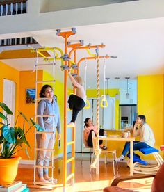 a woman hanging upside down on a pole in a living room with people sitting around